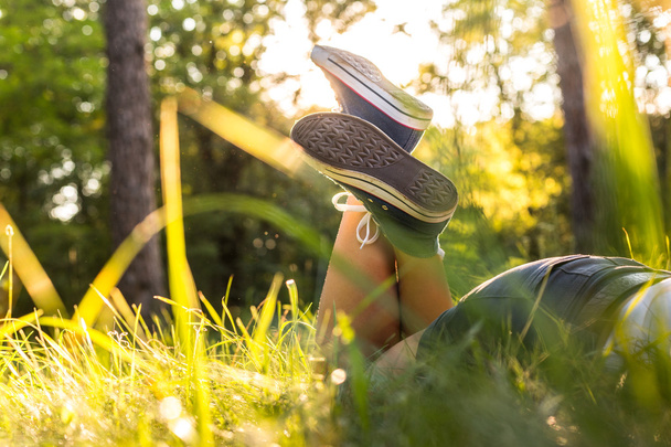 Lying on a grass in sneakers - Foto, afbeelding