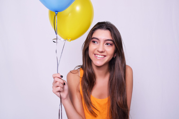 Happy young woman holding colorful balloons - Fotografie, Obrázek
