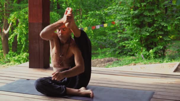 L'uomo al sito nel parco yoga, eseguendo asana
. - Filmati, video