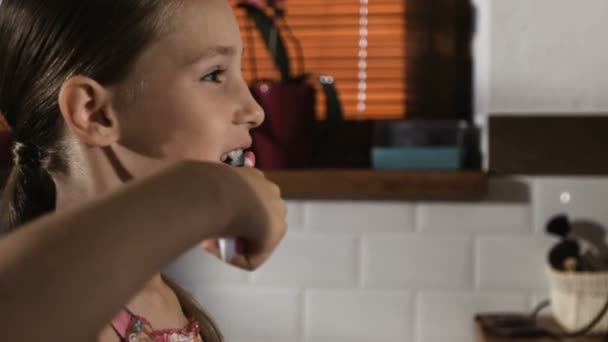Malá holčička v růžové pyžamo v koupelně čistit zuby, detail - Záběry, video