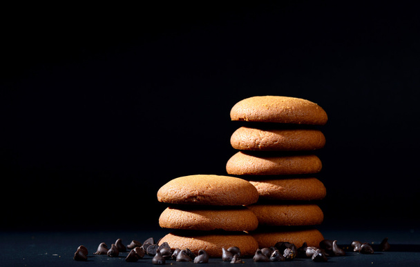 Delicious cream biscuits, Biscuits filled with chocolate cream. Chocolate cream cookies. brown chocolate biscuits with cream filling on black background. - Photo, image