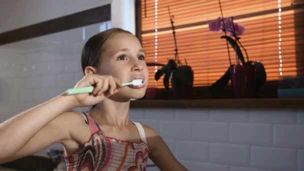 Menina em pijama rosa no banheiro escovando os dentes, close-up
 - Filmagem, Vídeo
