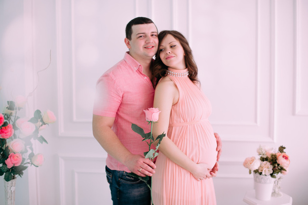 Familia esperando el nacimiento del bebé. Una mujer embarazada y su marido con ropa blanca
 - Foto, Imagen