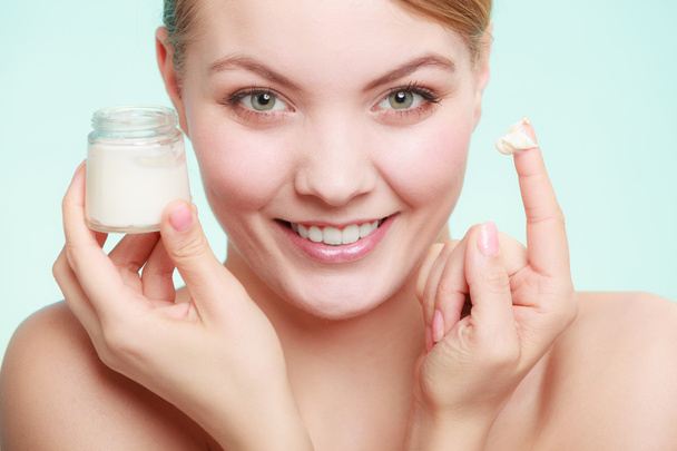 woman applying cream on her skin face. - Foto, afbeelding