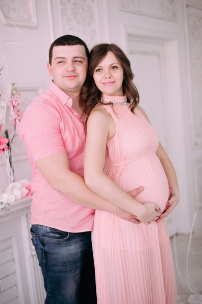 Famiglia in attesa della nascita del bambino. Una donna incinta e suo marito indossano abiti bianchi
 - Foto, immagini