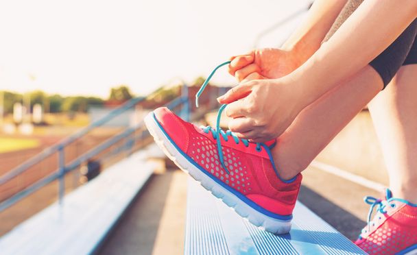 Femmina jogger legando le scarpe sulle gradinate
 - Foto, immagini