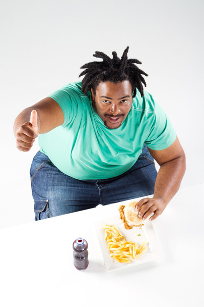 Overweight african american man eating hamburger - Foto, Imagen