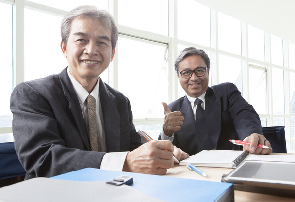 два азіатських бізнесмена зубне усміхнене обличчя, відпочиває в офісі
 - Фото, зображення