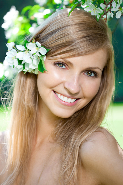 Smiling beautiful woman with flowers - Фото, изображение