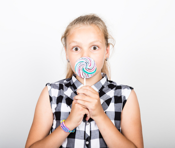Portrait of happy beautiful young girl licking sweet candy and expressing different emotions. pretty teenager girl with big circle lollipop - Photo, Image