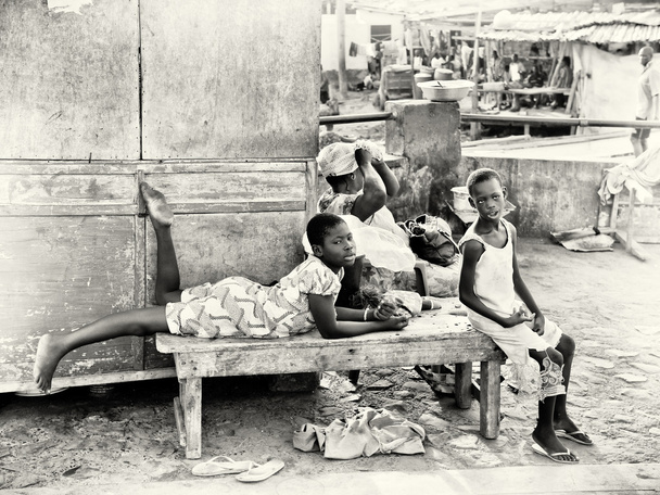 Two Ghanaian boys sit on a bench near the market - Photo, image