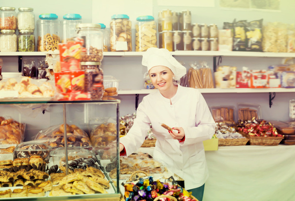 Happy woman seller offering sweets  - Фото, изображение