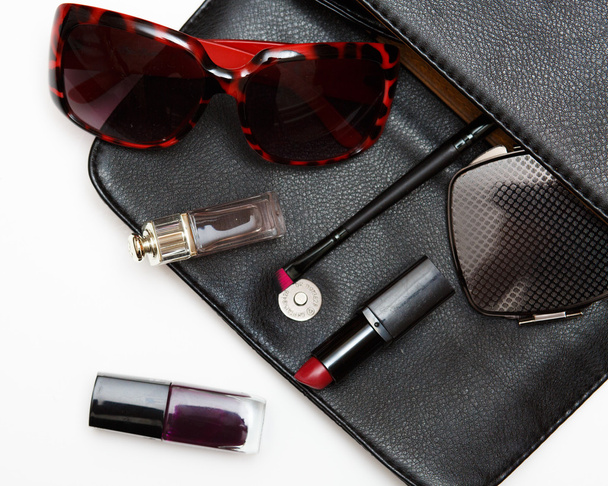 Top view accessories for woman. Stylish sunglasses, black leather bag , lipstick , perfume , fashion   flat lay on white - Foto, imagen