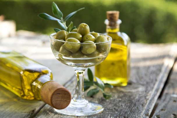 glass cup full of olives with green background - Foto, Imagen