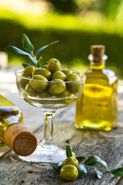glass cup full of olives with green background - Photo, image