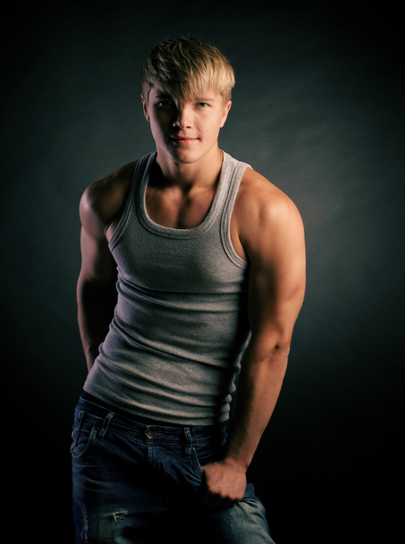 Beautiful young strong man posing on studio - Fotó, kép
