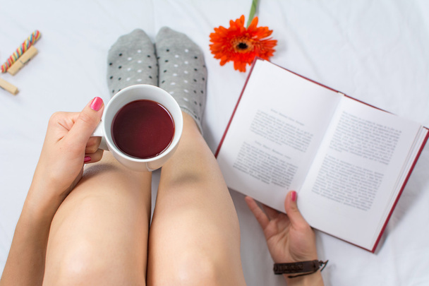 Mujer leyendo un libro y tomando una taza de té
 - Foto, imagen