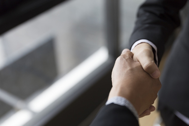 businessmen in suit shaking hands beside window - business teamw - Photo, image