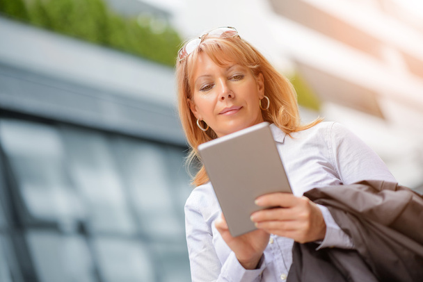 Mature businesswoman working on a digital tablet - Photo, Image