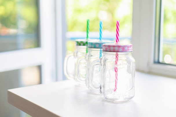 Three canning jars with colorful gingham lids, selective focus. - Zdjęcie, obraz