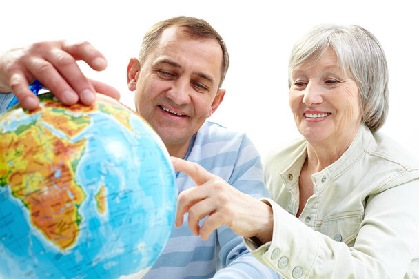 glückliches Seniorenpaar blickt auf Globus - Foto, Bild