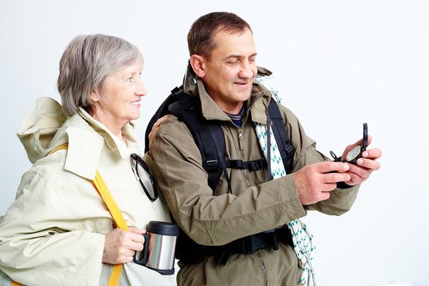 Para starszy patrząc na kompas na wycieczkę - Zdjęcie, obraz