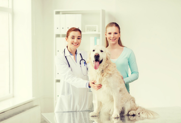 happy woman with dog and doctor at vet clinic - Photo, Image