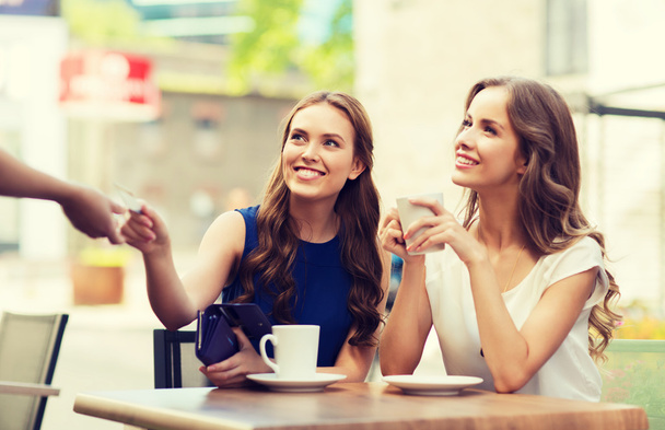 mujeres con tarjeta de crédito que pagan por el café en la cafetería
 - Foto, imagen