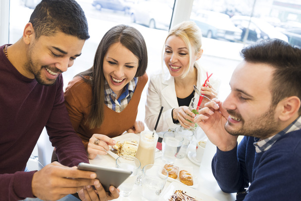 Onnelliset nuoret pitävät hauskaa kahvilassa, syövät kakkua
 - Valokuva, kuva