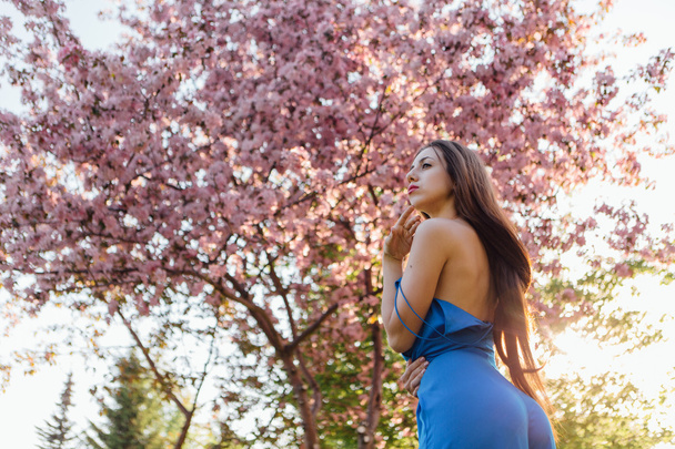 Beautiful young woman standing near the apple tree. - Fotografie, Obrázek