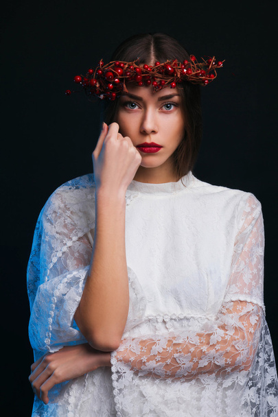 Girl with a wreath on his head on a black background - Foto, imagen