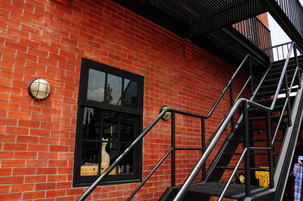 Black steel stair and brick wall - Fotó, kép
