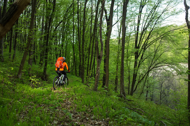 Biker in orange jersey on the forest road - Foto, Imagem