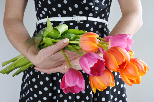 Weergave van Infocentrum lichaam van een vrouw in een jurk houdt Tulip bloemen boeket. Vrouwen vakantie concept. kopie ruimte - Foto, afbeelding
