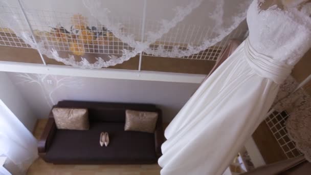 Vestido de novia blanco perfecto en percha y zapatos de moda en la habitación de la novia
 - Metraje, vídeo