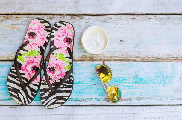 Akcesoria plażowe. Letnie buty i ręcznik okulary drewniane tła - Zdjęcie, obraz
