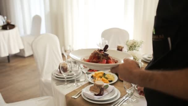 A pincér szolgál rusztikus esküvői asztalra fehér díszítéssel, közelkép - Felvétel, videó