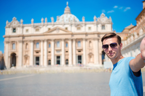 Jovem tomando fundo selfie Igreja Basílica de St. Peters na cidade do Vaticano, Roma. Turista caucasiano fazendo selfie foto foto em férias europeias na Itália
. - Foto, Imagem