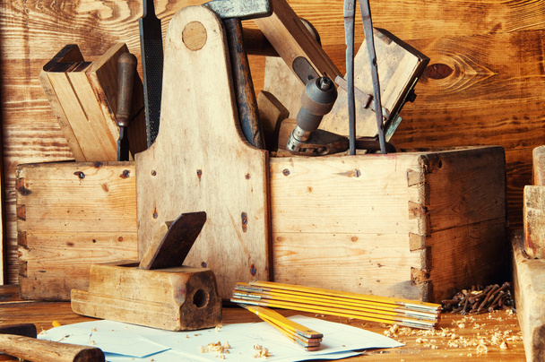 Carpintero de equipo en un escritorio de madera con planos
 - Foto, Imagen