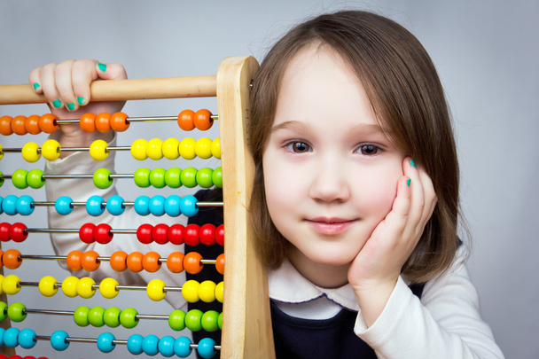 Jong meisje met abacus camera kijken. - Foto, afbeelding