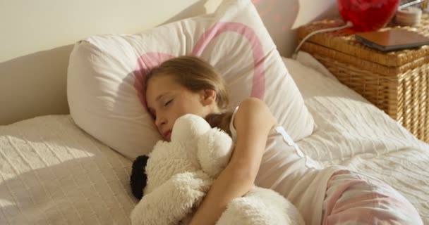 entzückende süße erwachendes Mädchen im Bett mit ihrem Spielzeug - Filmmaterial, Video