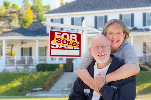 Pareja de adultos mayores en frente del cartel de bienes raíces, Casa
 - Foto, Imagen