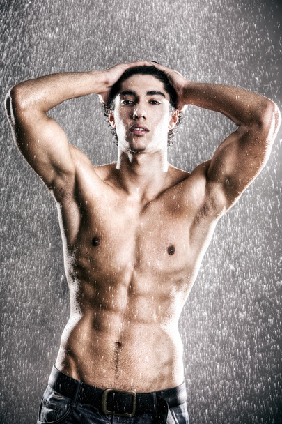 Young muscular man under the rain - Фото, изображение