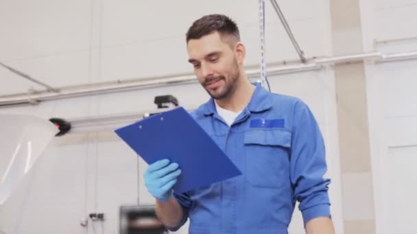 Mechanic man with clipboard at car workshop - Filmmaterial, Video