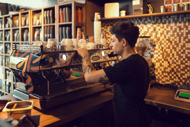 Barista at work in a coffee shop - Фото, изображение