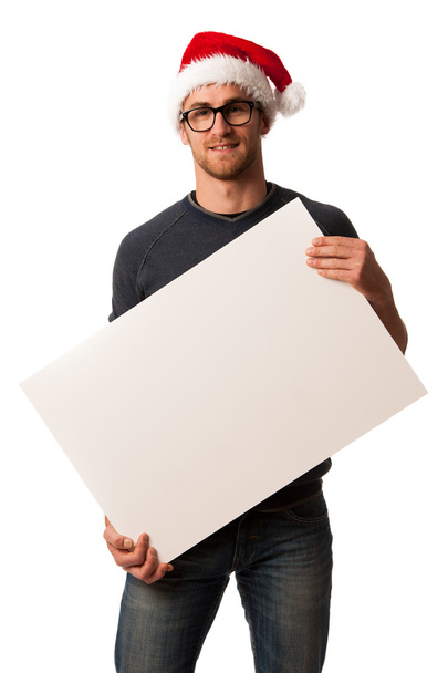 Young man in santa hat holding blank board for advertisment.  - Foto, immagini