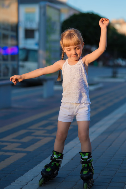 Little pretty girl on roller skates at a park - Photo, image
