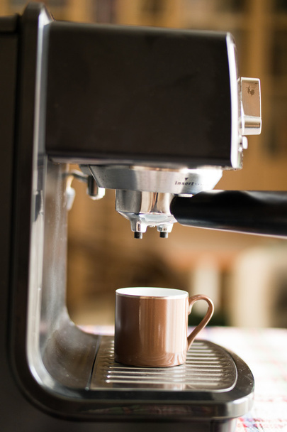 Espressomaschine, die Kaffee kocht und in eine braune Tasse gießt - Foto, Bild