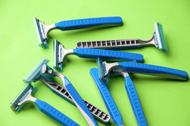 The image of blue razor blades ona a green bakground - Photo, Image