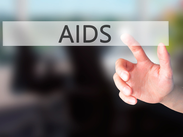 エイズ - v上のぼやけた背景の概念上のボタンを押す手 - 写真・画像